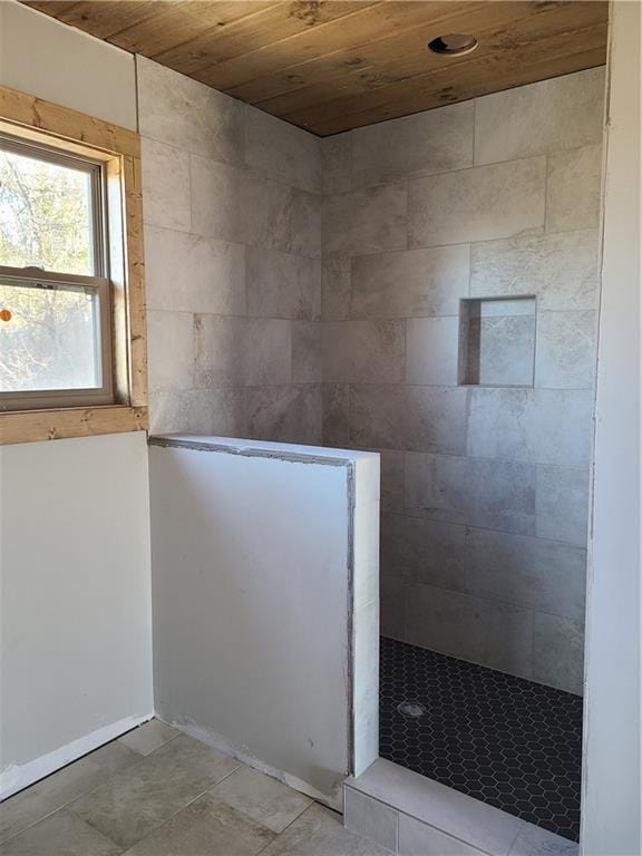 bathroom featuring wooden ceiling and a tile shower