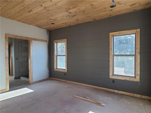 empty room with wood ceiling and baseboards