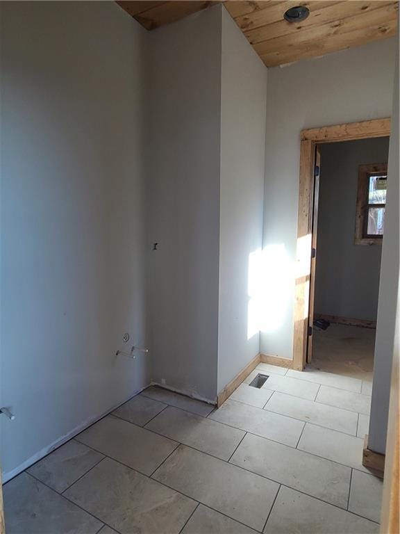 spare room featuring light tile patterned floors, wood ceiling, and baseboards