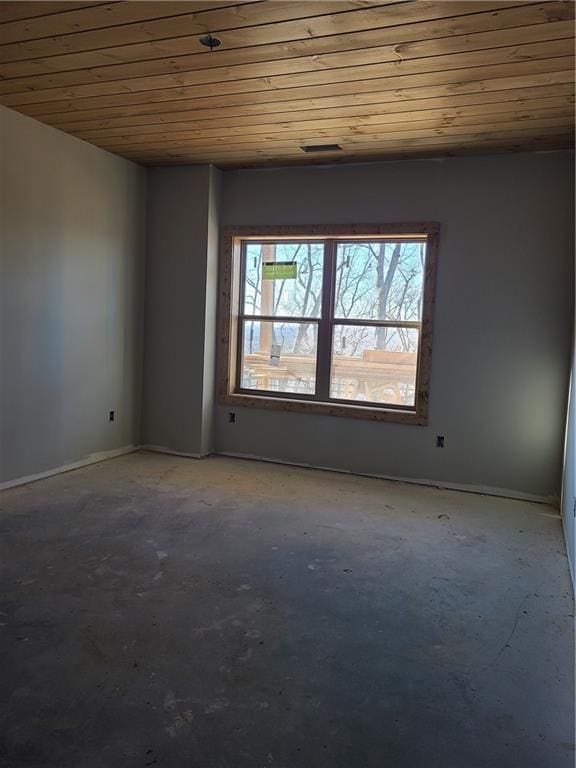 empty room with concrete floors and wood ceiling