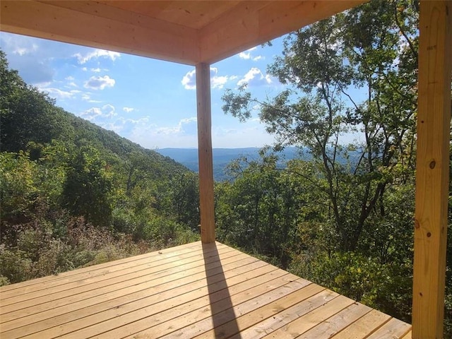 wooden terrace featuring a view of trees