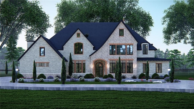 french country inspired facade featuring a front lawn