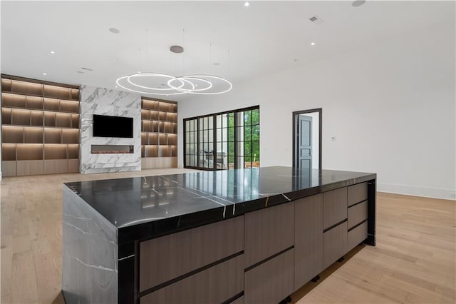 kitchen featuring decorative light fixtures, a center island, and light hardwood / wood-style flooring