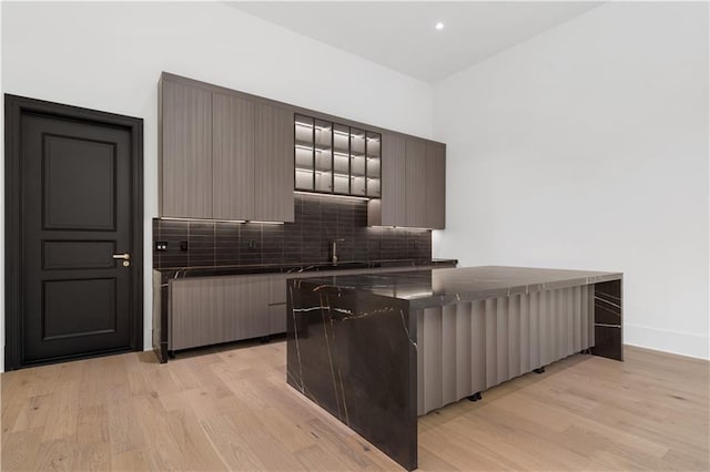 kitchen featuring sink, light hardwood / wood-style floors, and backsplash