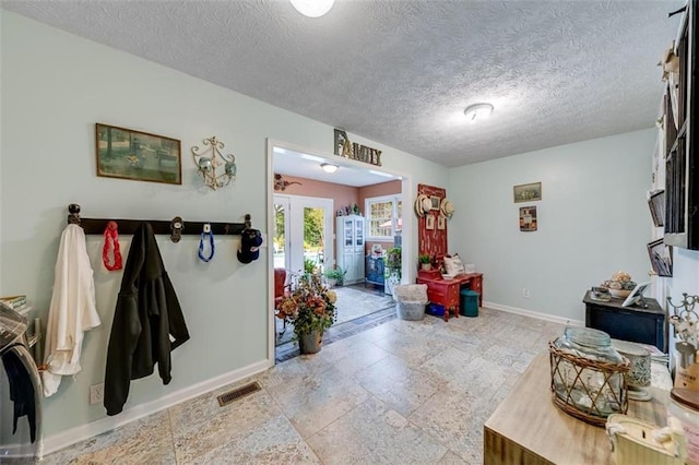 foyer entrance with a textured ceiling