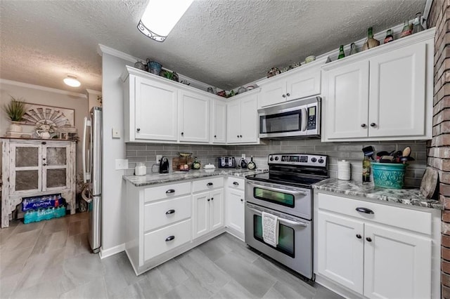 kitchen featuring backsplash, crown molding, stainless steel appliances, and white cabinets