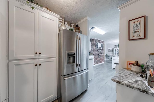 kitchen featuring light stone countertops, white cabinetry, a textured ceiling, and stainless steel fridge with ice dispenser