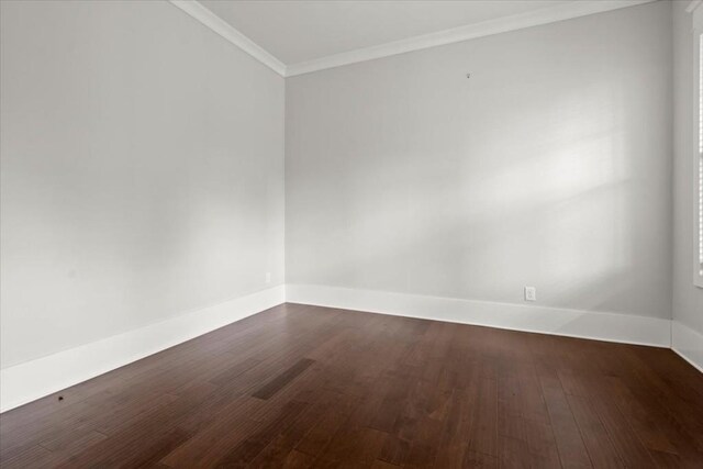 spare room with dark wood-style floors, baseboards, and crown molding