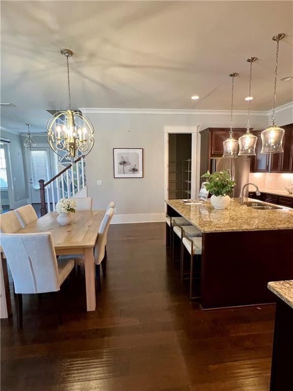 dining area featuring dark wood-style floors, ornamental molding, and baseboards