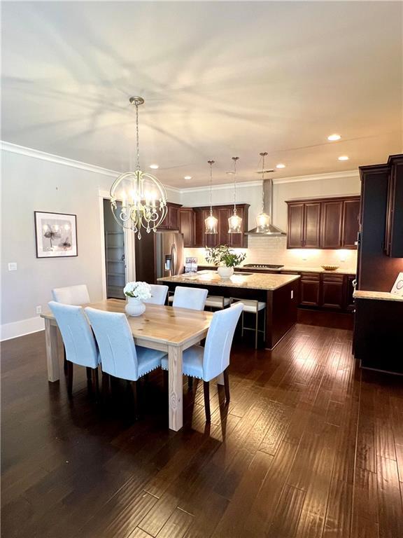 dining room featuring baseboards, dark wood finished floors, ornamental molding, a notable chandelier, and recessed lighting