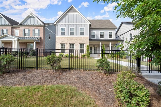 view of front of home featuring board and batten siding, a front yard, and a fenced front yard