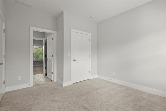 unfurnished bedroom featuring baseboards and light colored carpet