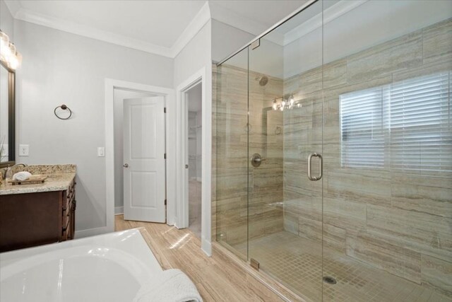 bathroom with ornamental molding, a shower stall, vanity, wood finished floors, and baseboards