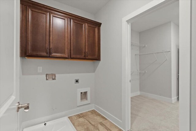 laundry room with hookup for a washing machine, light carpet, baseboards, cabinet space, and electric dryer hookup