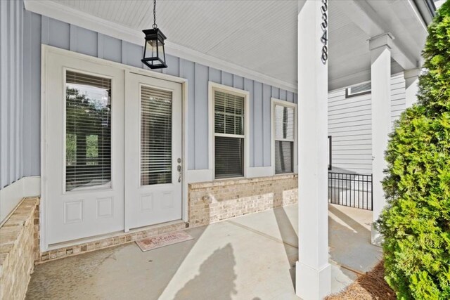 doorway to property featuring board and batten siding and brick siding