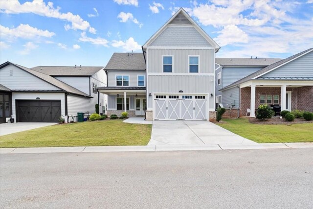 view of front of property with concrete driveway, an attached garage, a front lawn, a porch, and board and batten siding