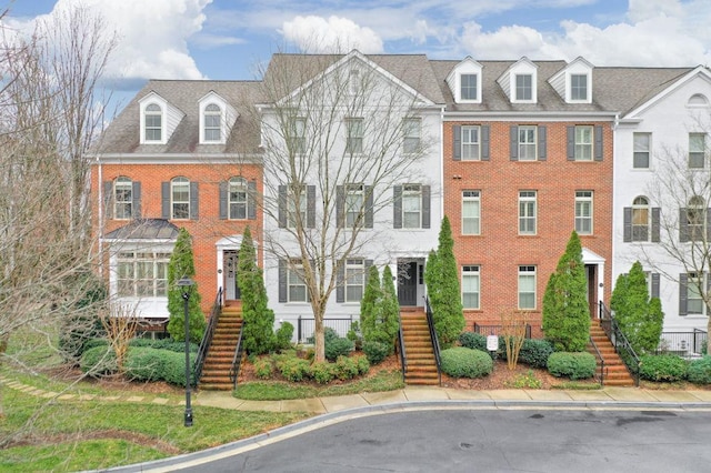 townhome / multi-family property featuring brick siding and stairs