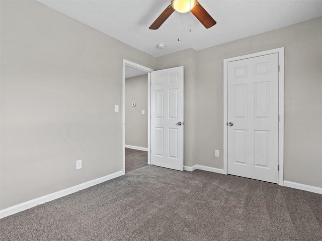 unfurnished bedroom with dark colored carpet and ceiling fan