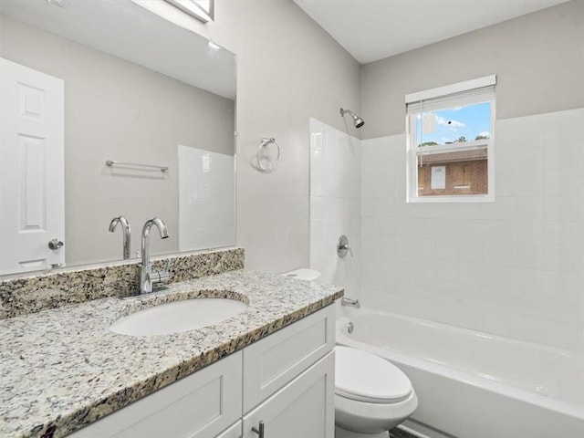 full bathroom with vanity, tiled shower / bath combo, and toilet