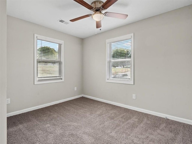 carpeted empty room with a wealth of natural light and ceiling fan