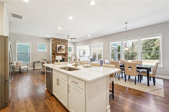 kitchen with visible vents, dark wood-style flooring, stainless steel appliances, and a sink