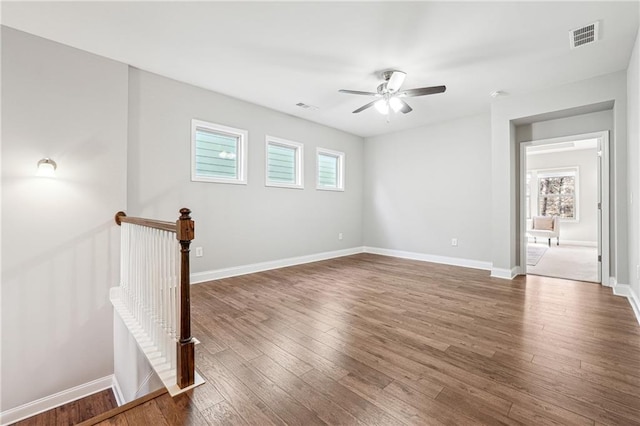 spare room with wood finished floors, a healthy amount of sunlight, and visible vents