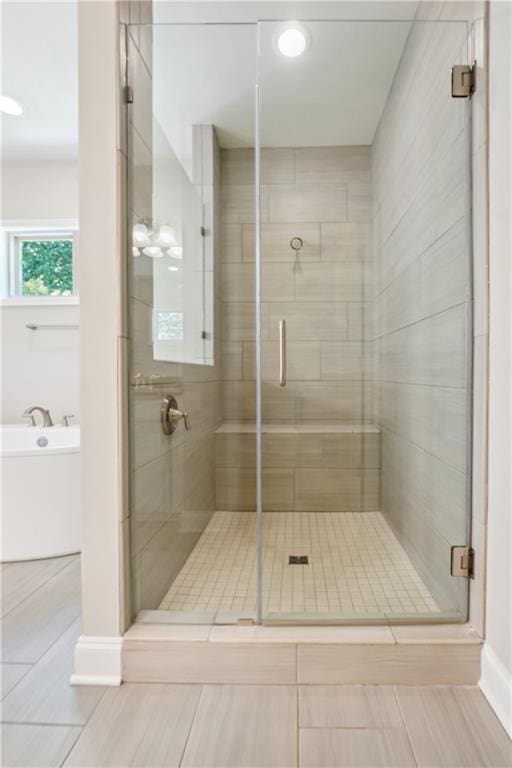 full bathroom with a bath and a shower stall