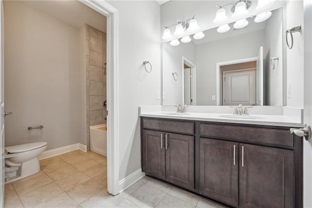 bathroom featuring baseboards, double vanity, a sink, tile patterned flooring, and toilet