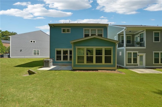 rear view of property featuring a patio area, a balcony, and a lawn