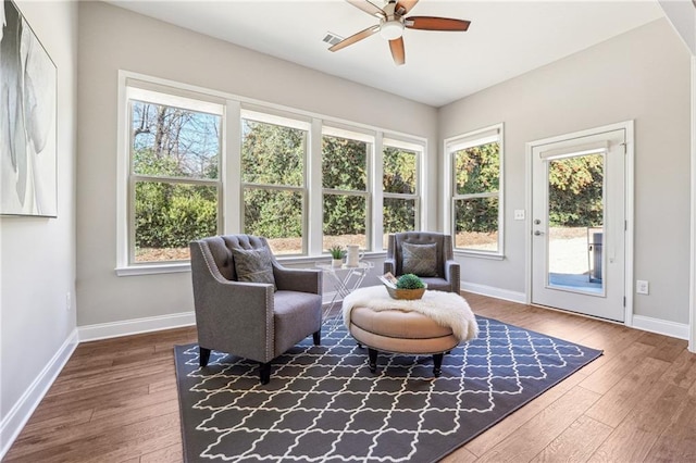 sitting room featuring a wealth of natural light, baseboards, wood-type flooring, and ceiling fan