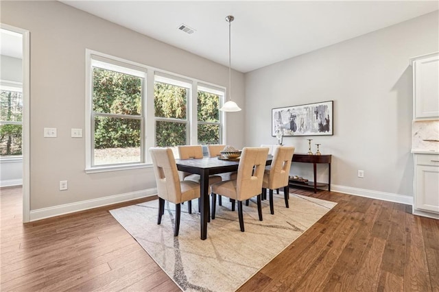 dining area with visible vents, wood-type flooring, plenty of natural light, and baseboards