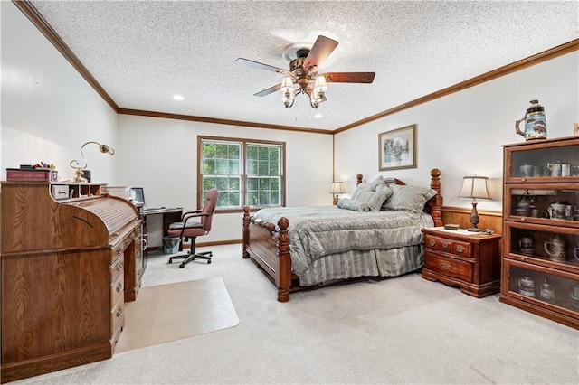 carpeted bedroom featuring ornamental molding, ceiling fan, and a textured ceiling