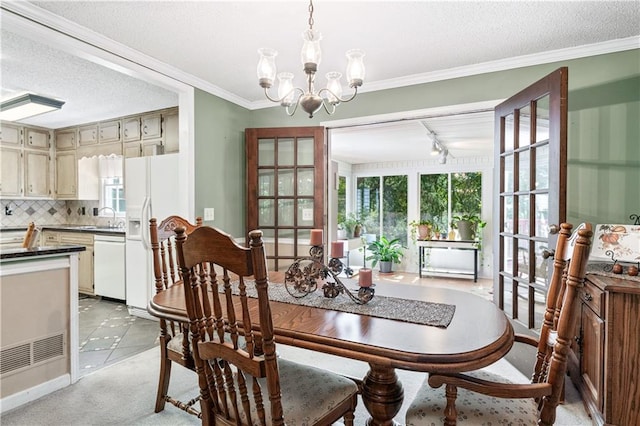 dining space featuring ornamental molding, an inviting chandelier, a textured ceiling, and light tile patterned flooring