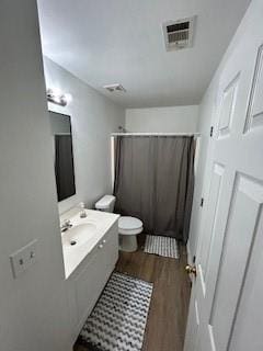 bathroom featuring vanity, toilet, and hardwood / wood-style flooring