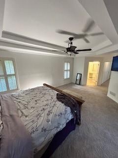 carpeted bedroom featuring ceiling fan, a raised ceiling, and multiple windows