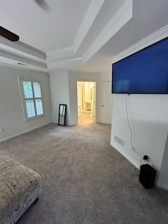 unfurnished bedroom with carpet flooring, ceiling fan, ornamental molding, and a tray ceiling