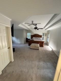 unfurnished bedroom with a tray ceiling and dark colored carpet