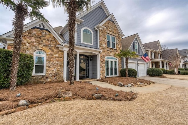 view of front of property with stone siding, concrete driveway, and a garage