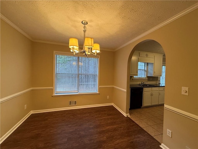 unfurnished dining area with arched walkways, wood finished floors, visible vents, plenty of natural light, and crown molding