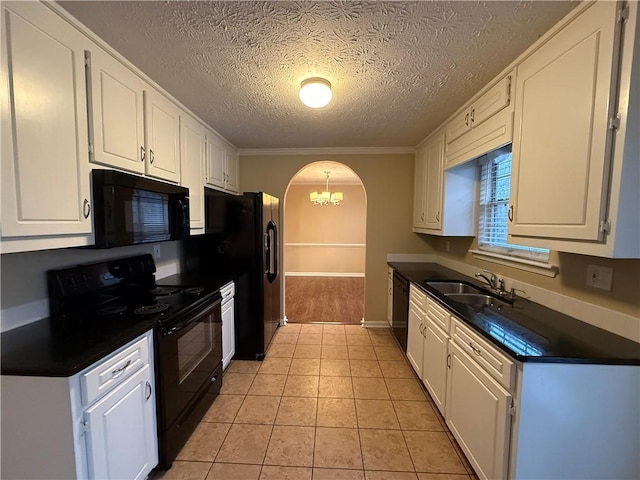 kitchen featuring dark countertops, black appliances, arched walkways, and a sink