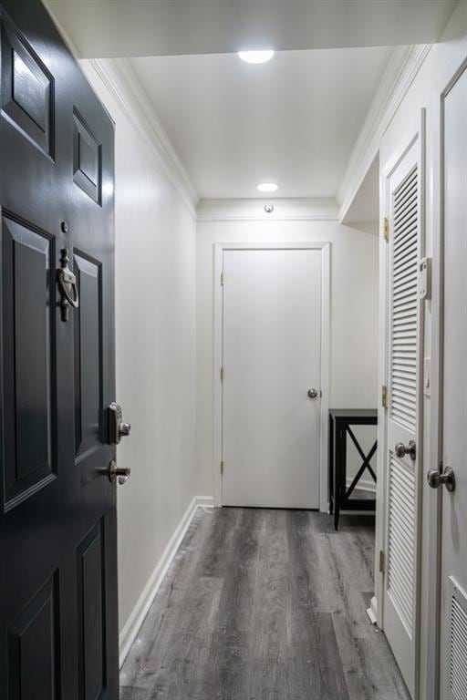 hall featuring dark wood-type flooring and crown molding