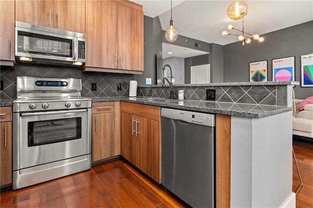 1080 Peachtree St NE Unit 2108, Atlanta, GA 30309 - kitchen featuring appliances with stainless steel finishes, a peninsula, dark wood-type flooring, and decorative backsplash