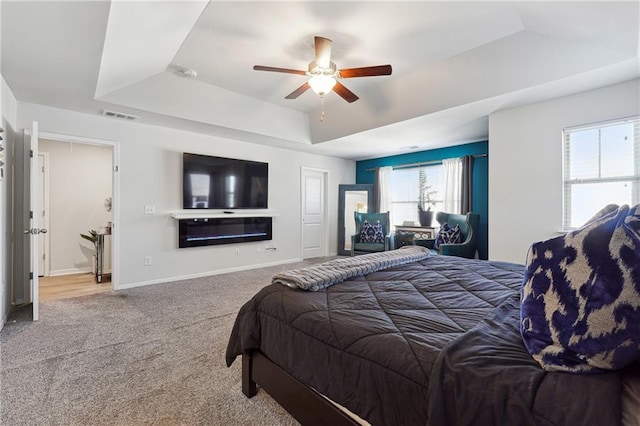 bedroom with ceiling fan, a raised ceiling, and carpet