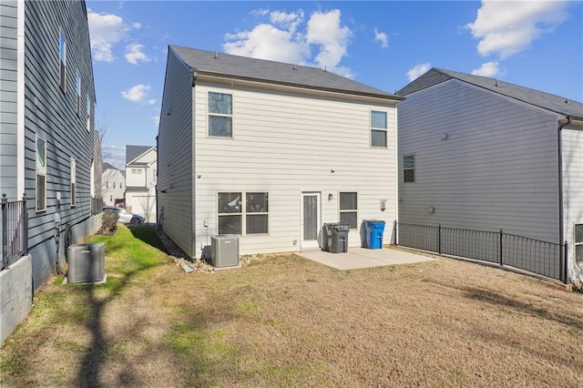 back of property with central AC, a patio area, and a lawn