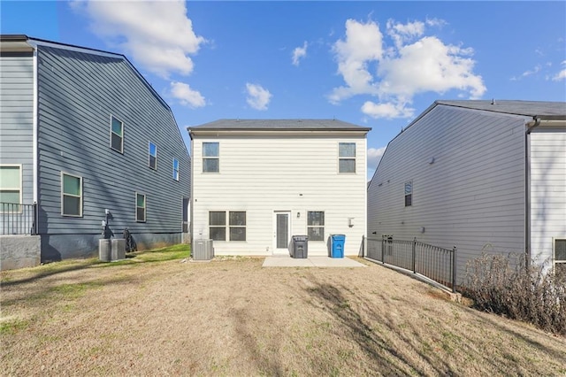 rear view of property with central AC, a patio area, and a lawn