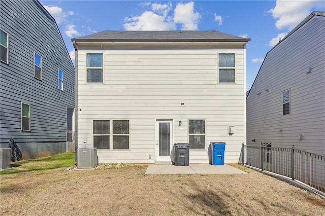 rear view of house with cooling unit, a yard, and a patio