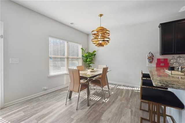 dining room featuring an inviting chandelier and light wood-type flooring