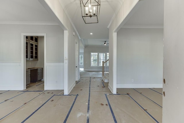 entryway with ceiling fan with notable chandelier and crown molding