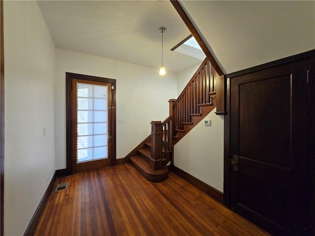 unfurnished living room with a fireplace, dark wood-type flooring, and french doors