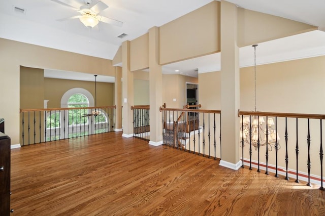 spare room featuring high vaulted ceiling, visible vents, baseboards, and wood finished floors